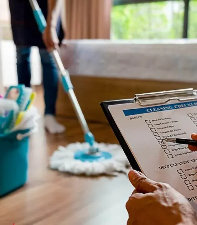 A person mops the floor while a clipboard with a checklist sits in the foreground, surrounded by cleaning supplies—an efficient scene perfected by a Virtual Assistant for Cleaning Business.