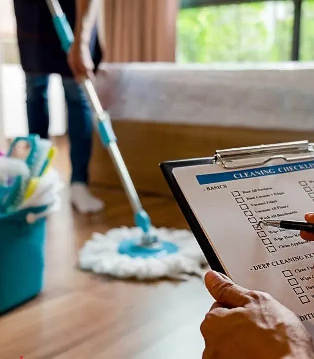 Create and Reach VA – Hero A person mops the floor while a clipboard with a checklist sits in the foreground, surrounded by cleaning supplies—an efficient scene perfected by a Virtual Assistant for Cleaning Business.